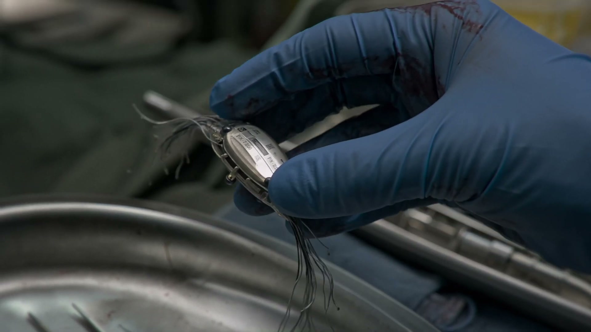 A neural implant recovered from the pilot's body — the hinge of the film's premise.